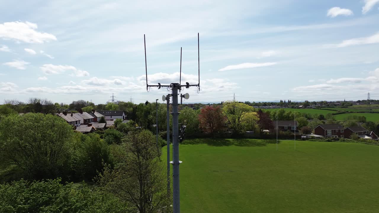 Aerial view circling neighbourhood sports field telecommunication tower for digital signals