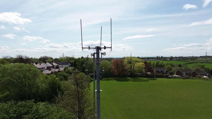 Aerial view circling neighbourhood sports field telecommunication tower for digital signals