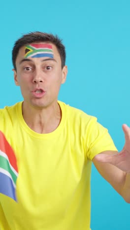 Man cheering for South Africa screaming and waving a national flag