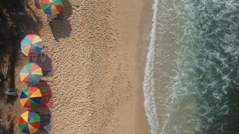 Vista-Aérea-De-La-Playa,-Volando-Sobre-La-Gente-Disfrutando-De-La-Orilla-Del-Mar-Con-Olas-Y-Sol