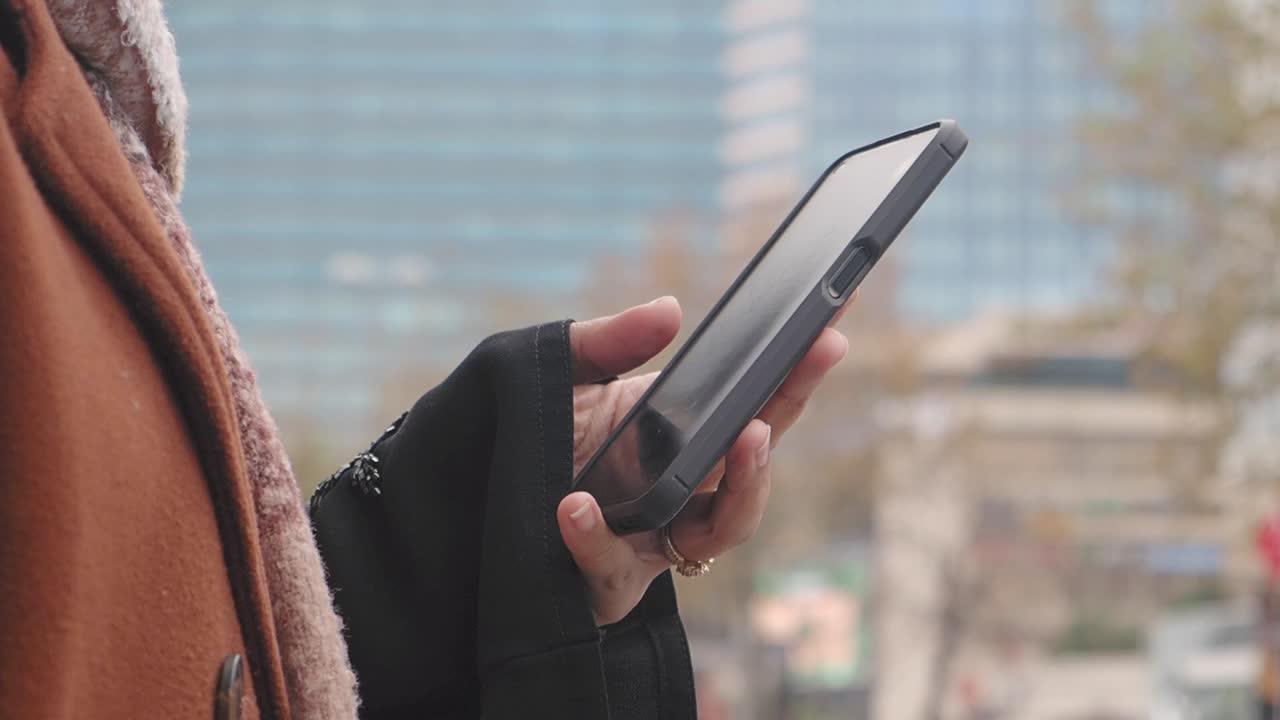 도시에서 스마트폰을 사용하는 여성