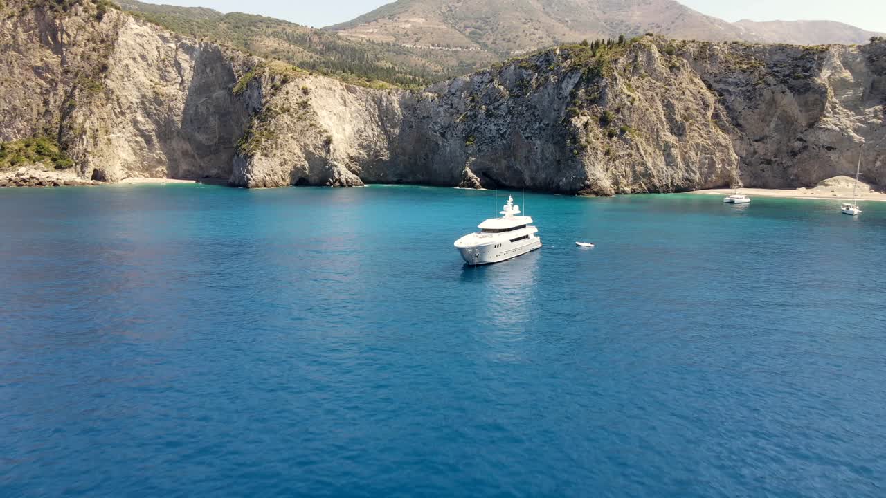 Yacht bianco in splendida baia marina con pittoresco paesaggio montano, ripresa aerea.