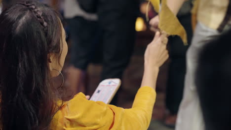 young vietnamese woman is happy winning traditional bai choi card game with yellow flags in hoi an