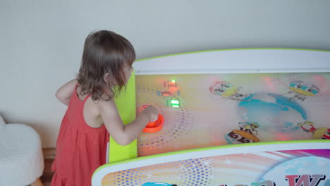 excited toddler girl jumps from happiness after scoring air hockey goal at game center - 120fps slow motion