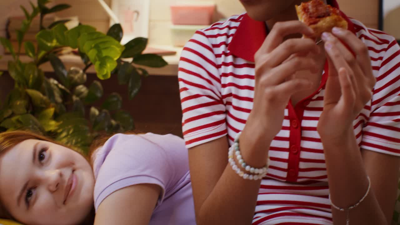 ragazze adolescenti che mangiano pizza in camera da letto