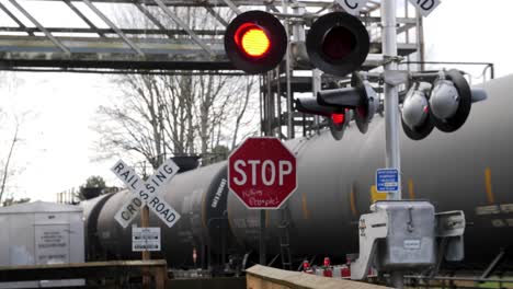 active railroad crossing sign with train passing in the background