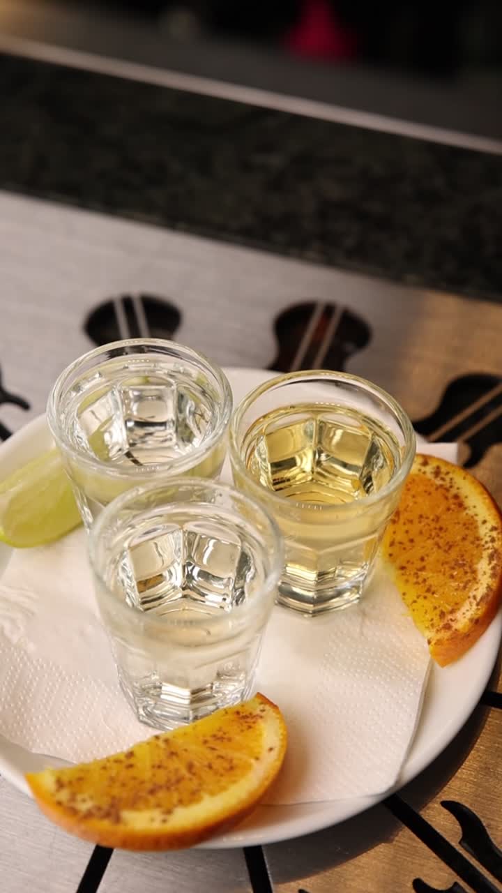 Tre shot di tequila con fette d'arancia e lime