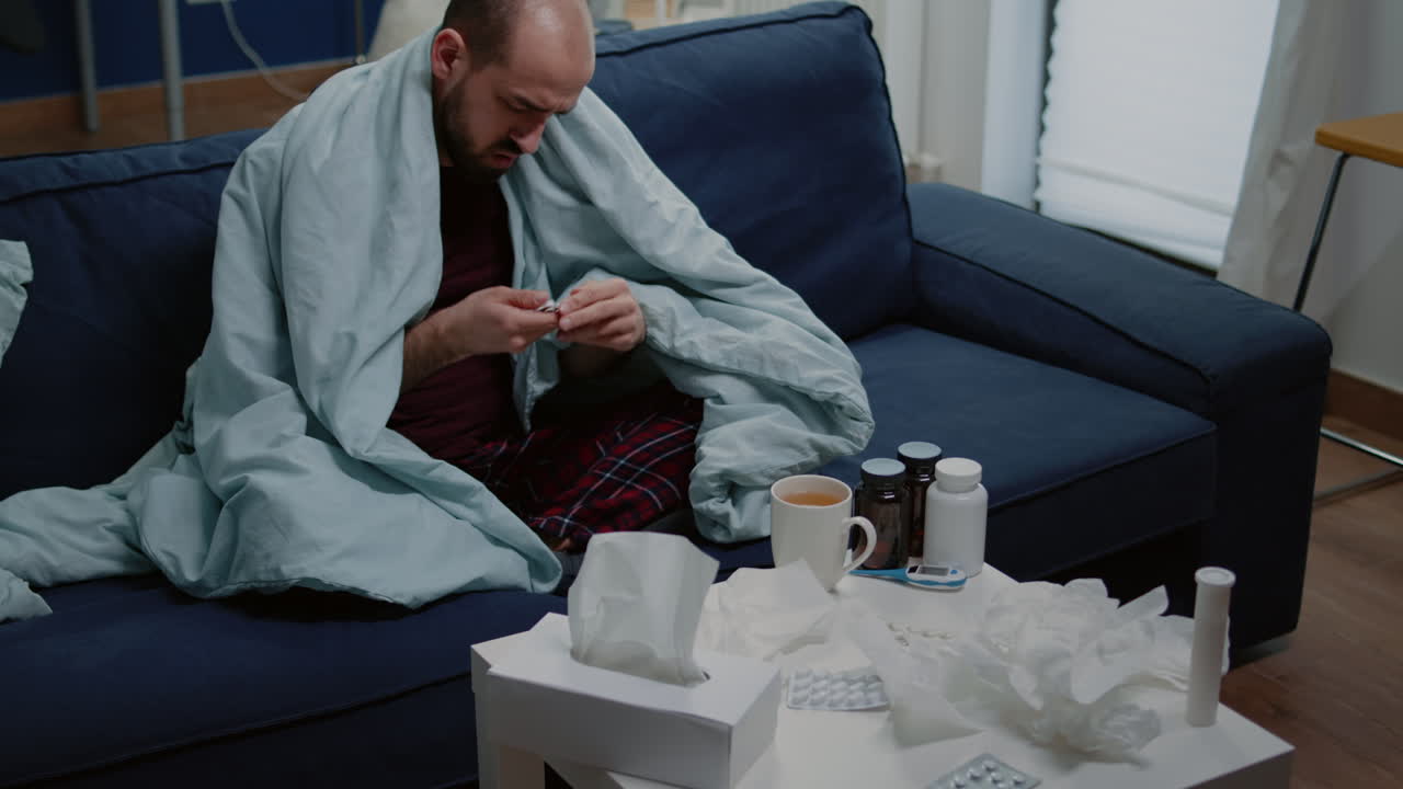 Unwell man searching for capsule tablets on table