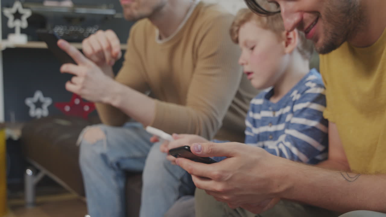 Slowmo of Same-Sex Couple and Boy Using Gadgets