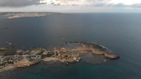 Vista-Aérea-De-Punta-Della-Mola-Con-Siracusa-Al-Fondo,-Aérea