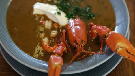 fresh healthy seafood soup red lobster crayfish served with smietana and parsley, traditional gourmet food dish