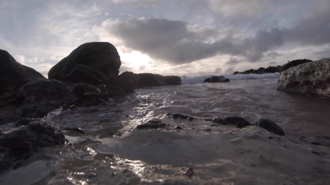 Water level view of waves crashing and rolling into shore in slow motion 2