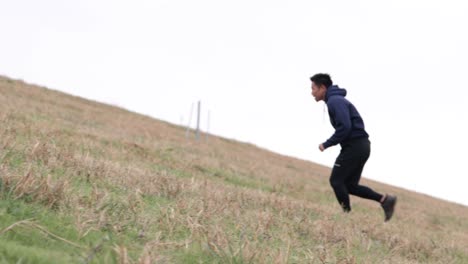 asian male running hills to train