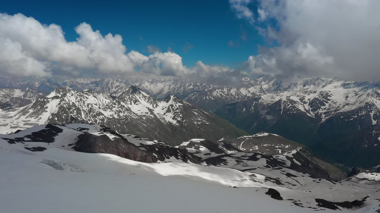눈 덮인 아름다운 산봉우리와 빙하 위로 산 구름을 통과하는 항공 비행.
