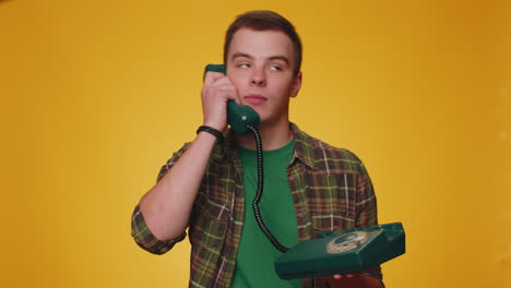 Crazy-tourist-hotline-agent-man-talking-on-wired-vintage-telephone-of-80s-fooling-making-silly-faces