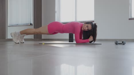 fitness enthusiast performing side plank exercise on mat in bright modern living room space active woman engaged in side plank workout on exercise mat in stylish living room showcasing strength and determination