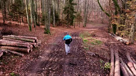 Hombre-Corriendo-Por-Un-Sendero-Forestal-En-El-Paisaje-Otoñal