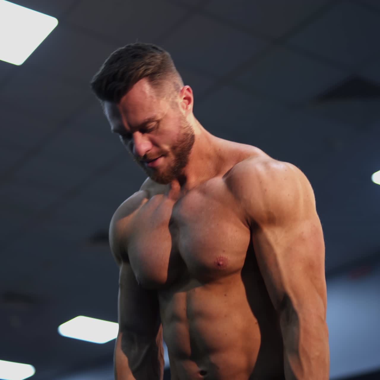 Shirtless athlete pumping muscles with a barbell. Sportsman doing weightlifting exercise in fitness gym. Healthy lifestyle. Close-up