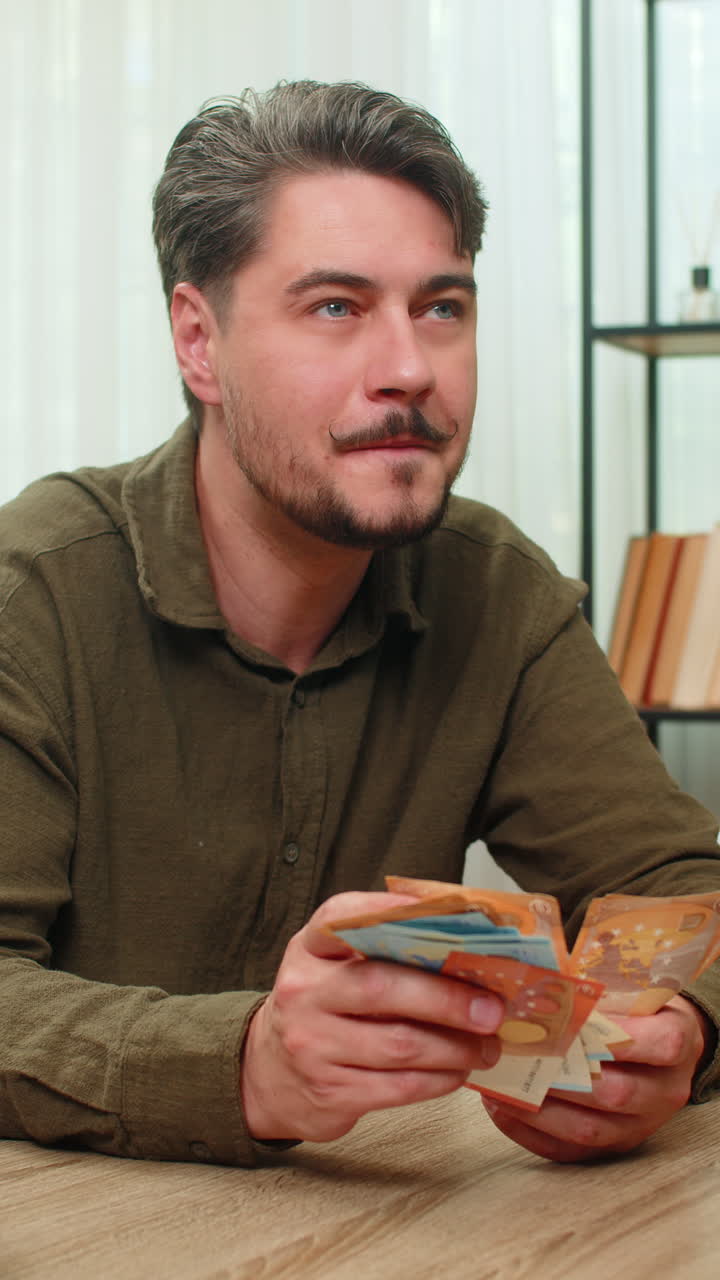 Middleaged man counts cash smiling showing big financial success euro bills wealth at table desk