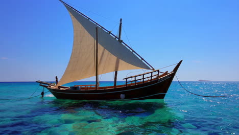traditional dhow sailboat in turquoise waters