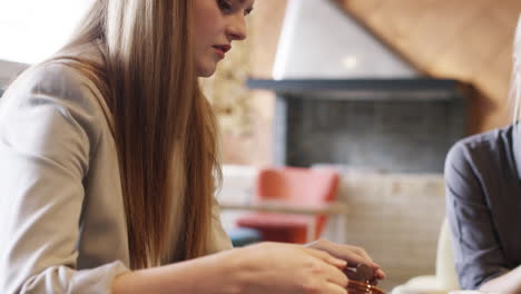 mujeres de negocios se reúnen en una cafetería usando una tableta digital