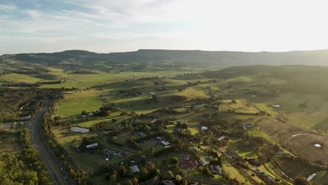 aerial orbit of minnamurra, australia, showing the quaint lush community village and surrounding landscapes at sunset