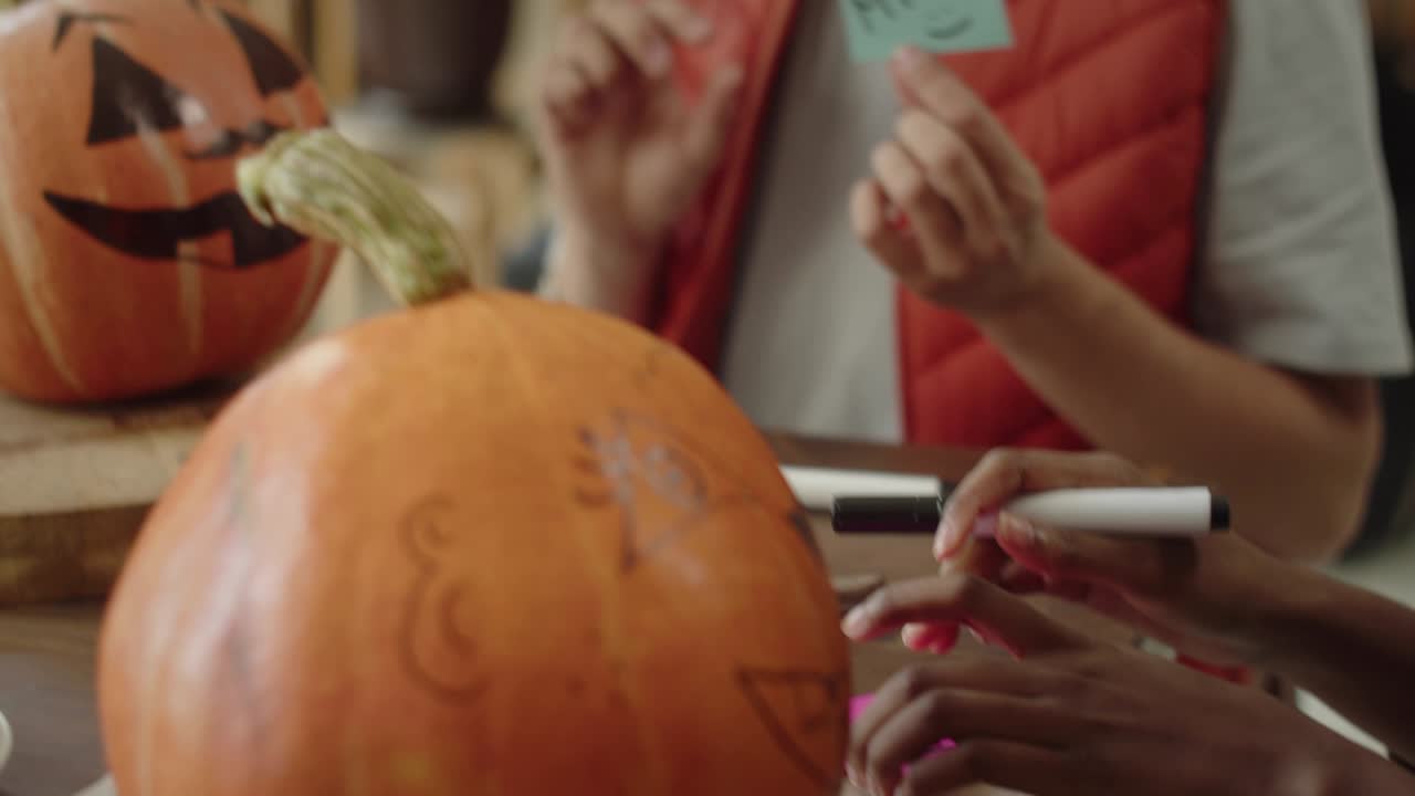 amigos pegan pegatinas con nombres en las calabazas de halloween.