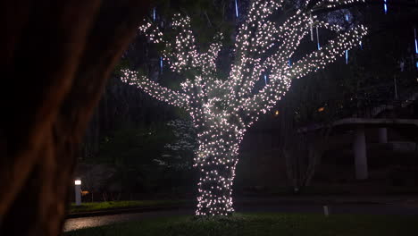 a beautiful tree decorated with lights at night for christmas, a museum, children's playground or special event - concept: perspective, dream world, pandora, mother tree, celebration, magic