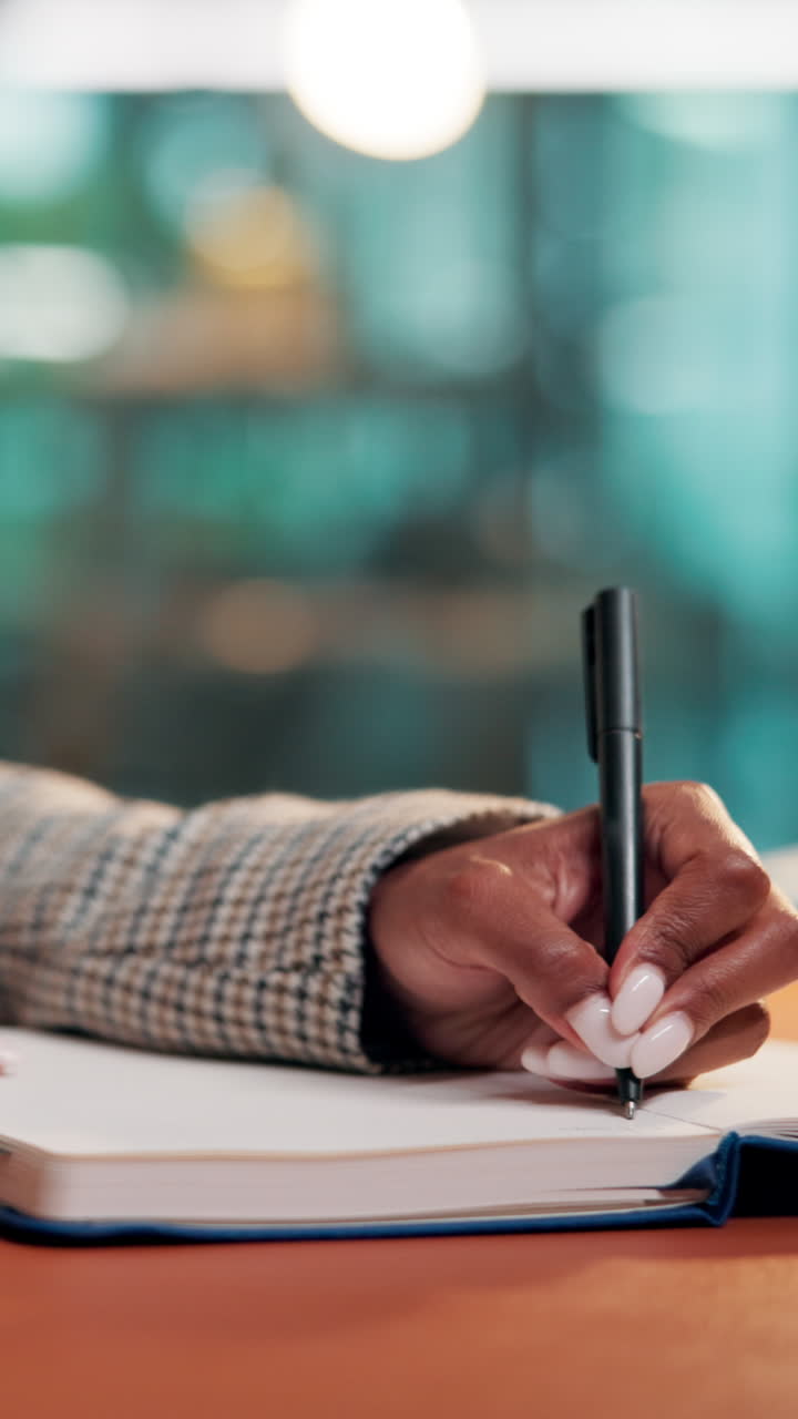 Close-Up of a Hand Writing in a Notebook with a Pen