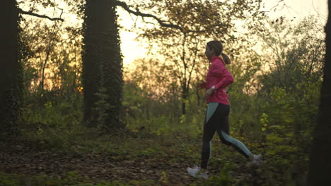 woman jogging in the forest at sunset