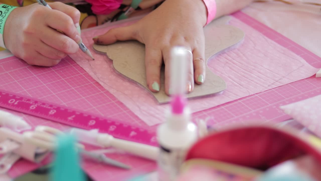 mujer en un taller de artesanía haciendo bocetos en papel rosa