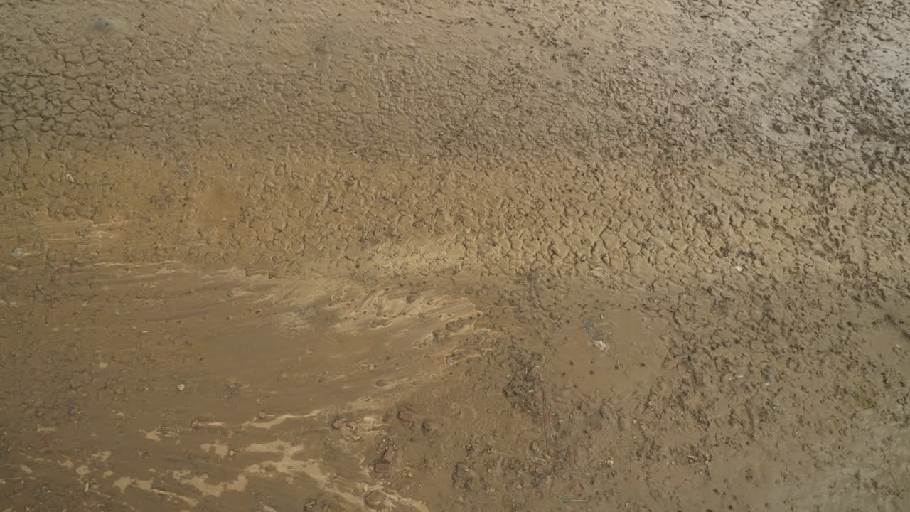 lecho de río seco con suelo agrietado en el fondo, restos de suelo húmedo en el clima de calor de verano, bihar, india