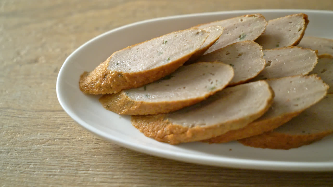 pastel de pescado chino frito o línea de bolas de pescado en tablero de madera