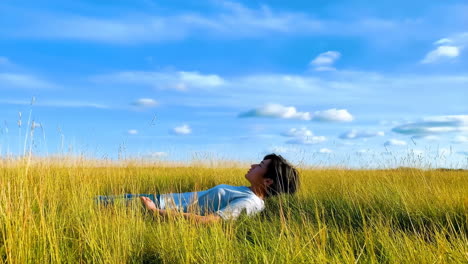 person relaxing in a grassy field under a blue sky