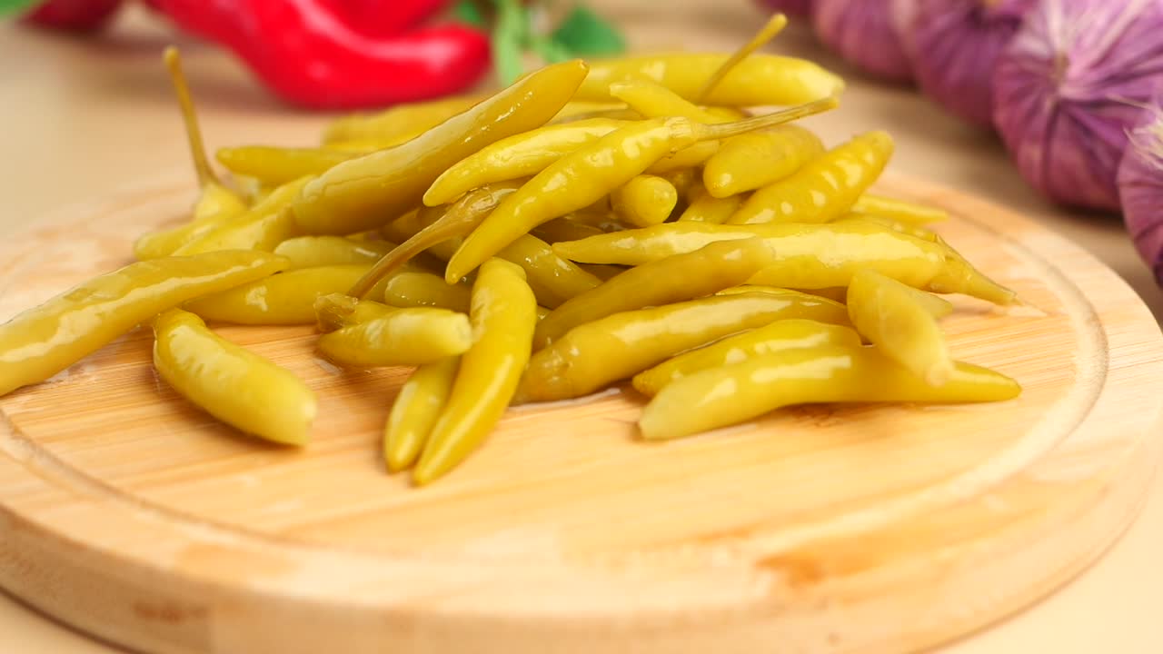 Pile of Pickled Green Chili Peppers on a Wooden Board
