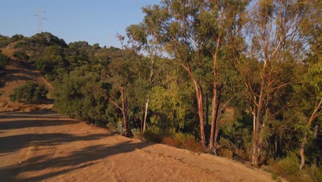 Aerial-view-moving-down-to-reveal-a-dirt-trail-on-the-mountains