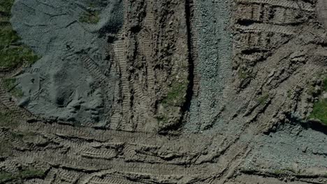 aerial top down view of field of gravel and earth with continuous vehicle marks