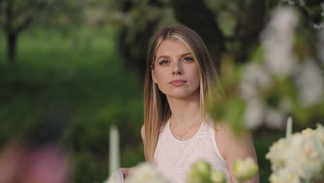 beautiful blonde woman in garden party portrait of lady at table in nature shy and calm female guest