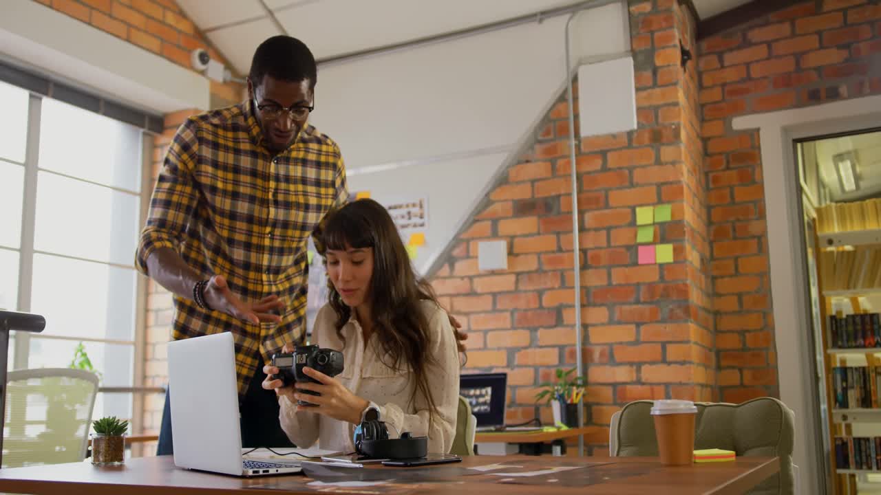 diseñadores gráficos discutiendo sobre fotografías en cámaras digitales en el escritorio 4k