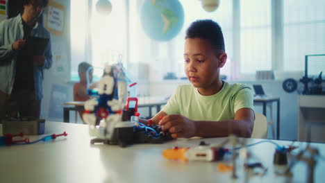 boy building a robot in a classroom
