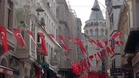 a narrow street in istanbul, turkey, with the galata tower in the background.