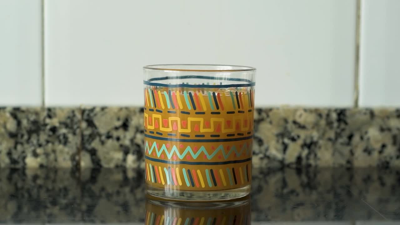 Filling a glass of fruit juice. Filling a glass of peach juice.