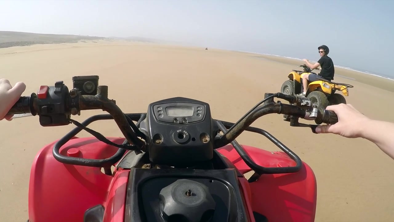 Ripresa POV Due. Gruppo di quad in corsa su una spiaggia deserta in Marocco, con tempo tempestoso.
