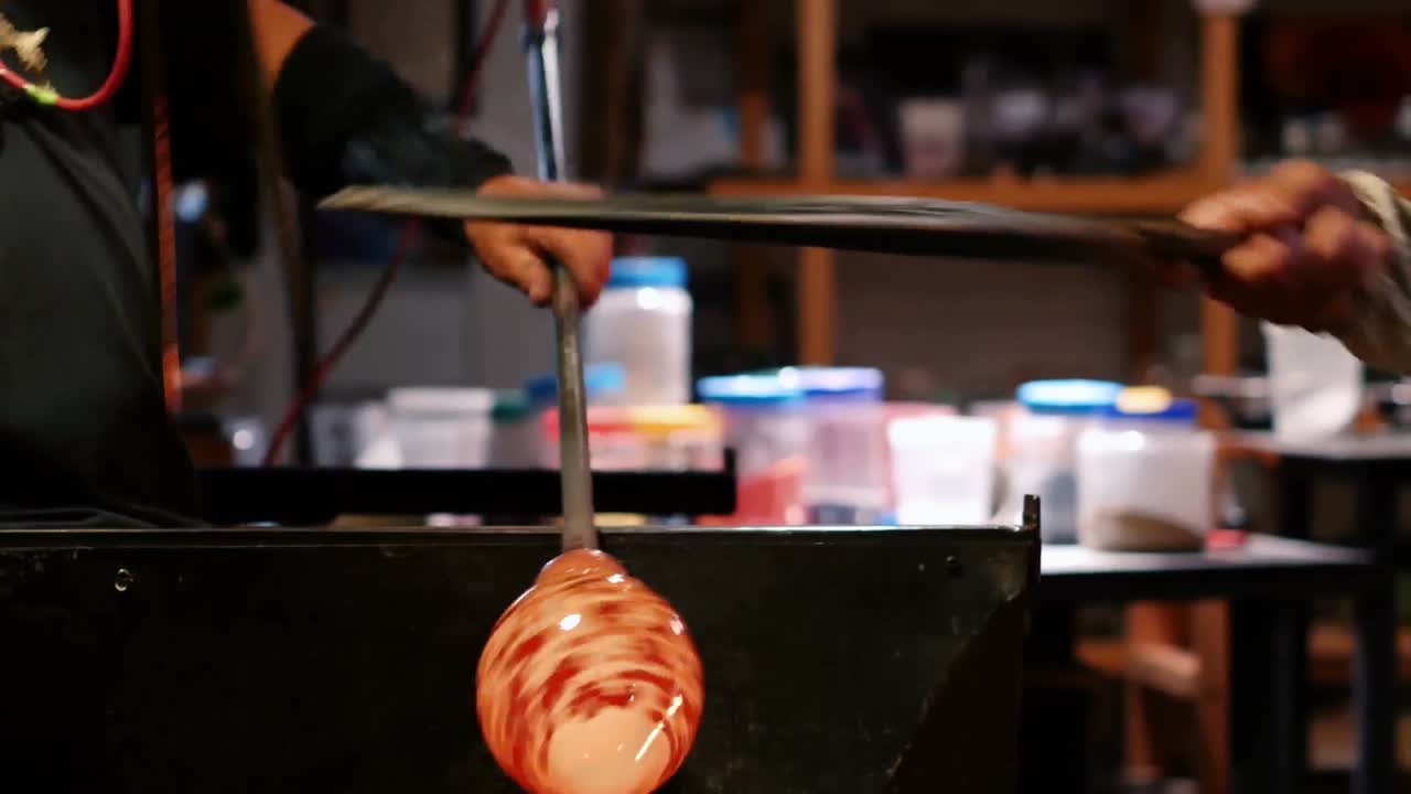 Team of glassblowers shaping a molten glass