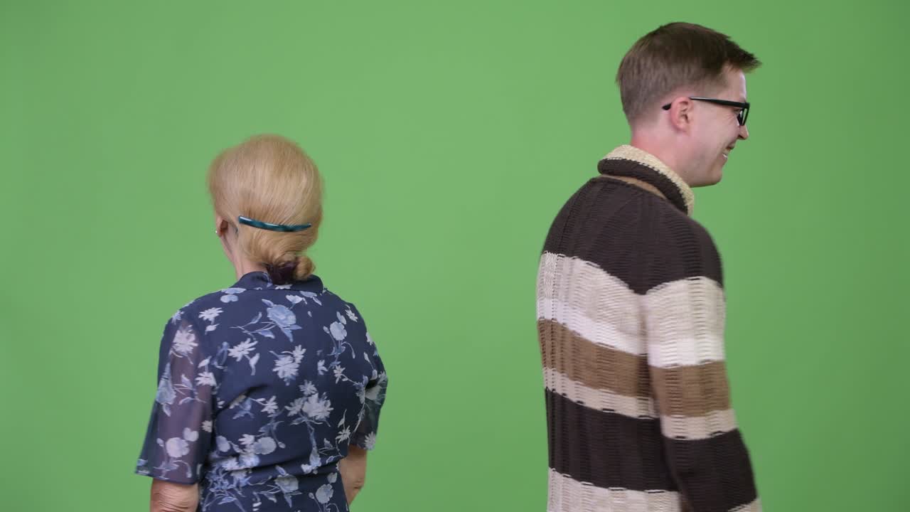 Grandmother and grandson turning then smiling with arms crossed together