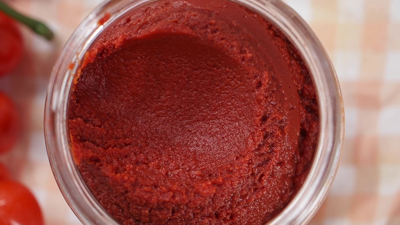 Overhead View of Vibrant Red Tomato Paste in a Glass Jar