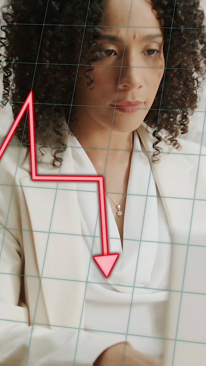 Vertical video: Woman reacting to market alert, red chart sweeping on laptop, aligning torso