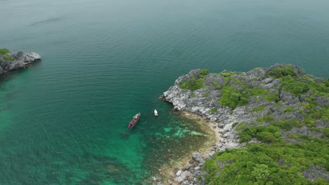 High-above-scenic-rocky-bay-on-Koh-Wao-island-in-Thailand,-boat-with-tourist-snorkeling