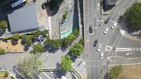 Aerial-birdseye-rising-from-Brisbane-traffic-on-sunny-day,-Queensland,-Australia