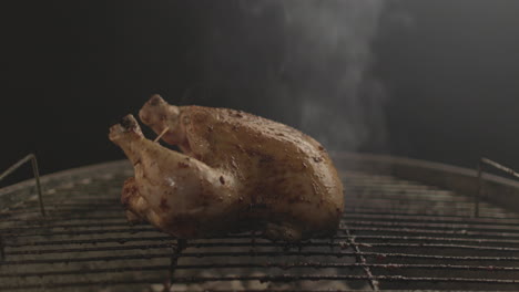 chicken getting grilled on coal and fire with smoke coming up with black background shot raw and 4k eye level